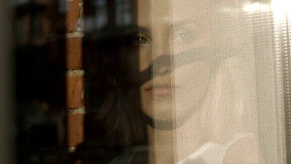 一个秋日一个忧伤的年轻女子透过窗户望出去的肖像