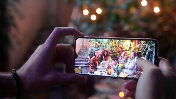 近距离男子用智能手机拍照的朋友用餐