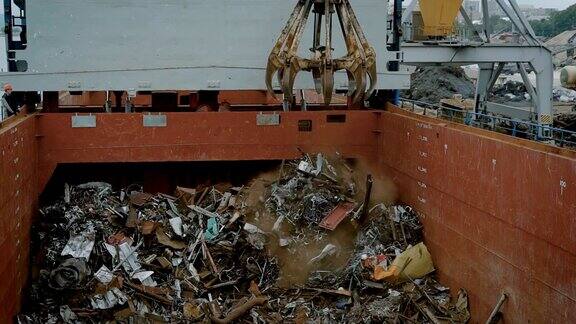 在集装箱内倾倒垃圾的过程中使用带有磁铁的起重机