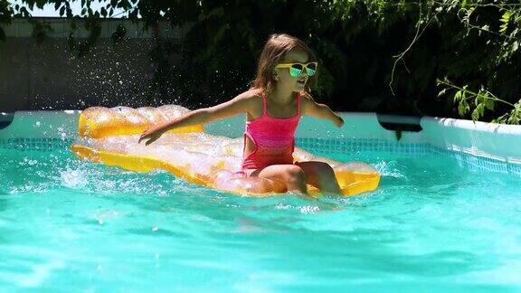 小女孩坐在黄色充气床垫上在游泳池里玩得很开心