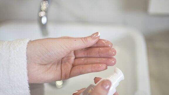 女性沐浴后手指上的护肤油粘度检查