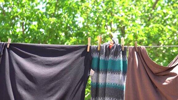 洗干净的衣服挂在铁丝上挂着衣夹模糊了村庄里的春色背景