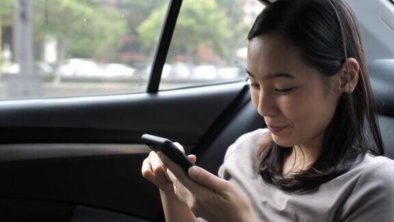 亚洲女人在汽车上使用手机