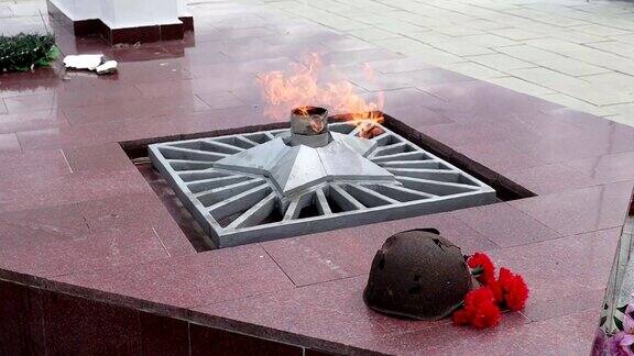 纪念碑永恒的火焰生锈的头盔士兵的第二次世界大战鲜花