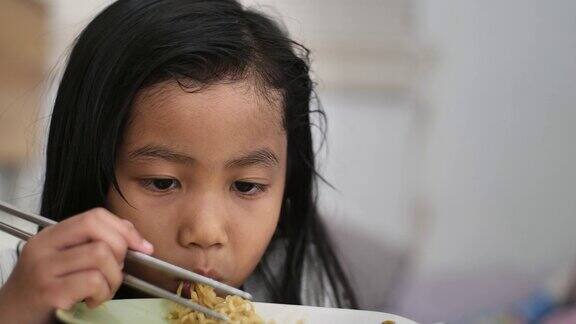亚洲小女孩用筷子吃面条孩子们享受她的饭菜