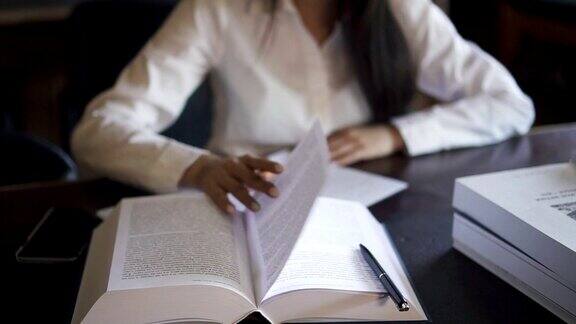 桌子上放着一本书穿着白衬衫的女学生正在做阴谋