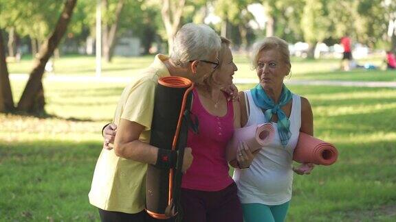 美丽的老年妇女与运动垫享受一天在公园