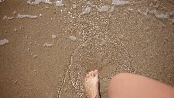 女人的腿在沙滩上行走