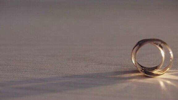 两个结婚戒指在地板上滚动