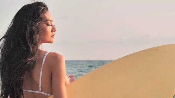 美丽性感的年轻女子冲浪女孩在日落或日出的海滩冲浪板在比基尼性感的女孩在日落比基尼假期iStock