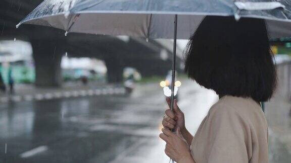 一个亚洲女人在雨中等出租车