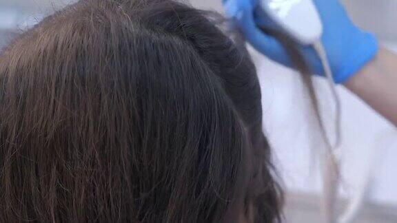 毛发医师在临床上使用毛发镜检查女性患者的毛发