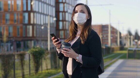 在城市里戴着医用防护口罩的女性通勤者