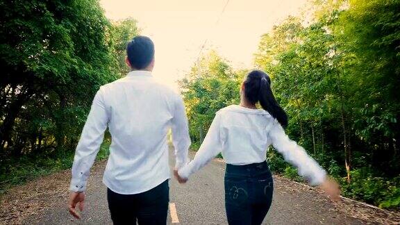 相爱的年轻夫妇喜欢在户外公园散步手牵着手