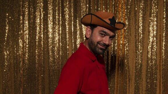 一个男人戴着派对牛仔帽在一个派对的照相亭里拍傻乎乎的照片