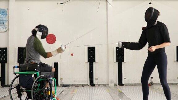 男子轮椅击剑运动员与他的女教练训练