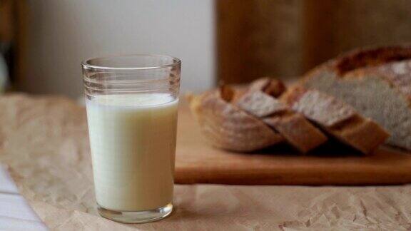 牛奶杯和切片面包在厨房的桌子上一杯牛奶和切片面包