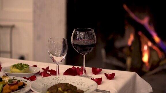 浪漫的红酒晚餐背后有柴火燃烧