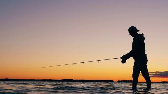 夕阳下的湖面上一个渔夫在抛钓竿