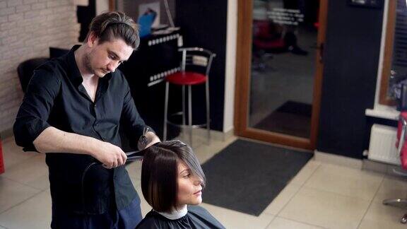 专业发型师、发型师在美容工作室为年轻女性制作专业发型用发夹固定发型头发拉直美容护发理念