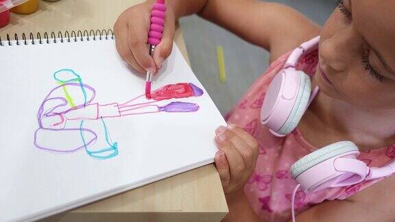 女孩正在用毛笔和蛋彩画一幅画