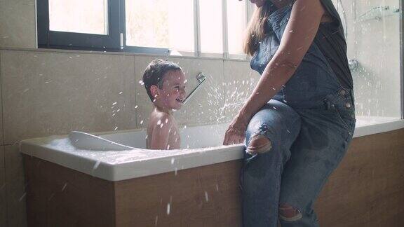 一个正在洗澡的小男孩和他怀孕的母亲在附近