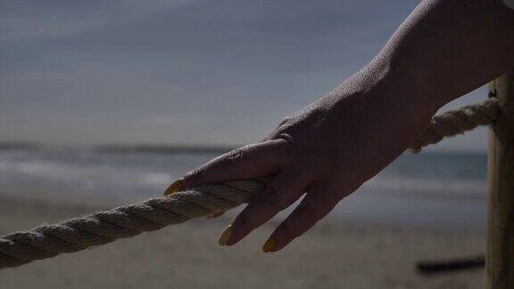 女人拉着绳子靠近海边