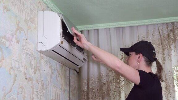 女人打开空调检查空气过滤器的状况
