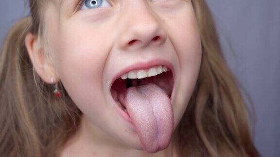 女孩张大嘴巴伸出长长的舌头孩子露出了他的牙齿