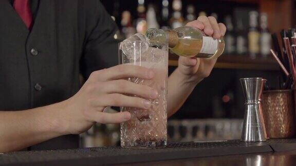 调酒师将瓶装苹果酒加到加冰的鸡尾酒中并制造泡沫
