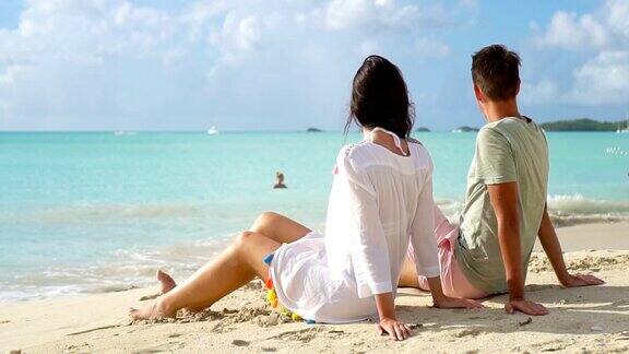 一对年轻夫妇在白色的海滩上度过暑假幸福的情侣们在异国的小岛上享受蜜月