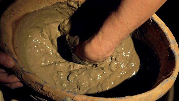 一个陶工手工搅拌湿粘土的特写