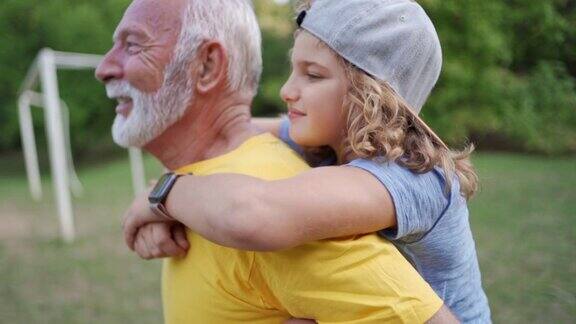 快乐的爷爷和他的孙子有这么多的乐趣和快乐在背背的时候他们有一些自然的体育活动