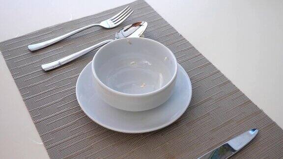 健康早餐干脆的麦片落进碗里碗的细节图桌上有玉米片和刀叉健康食品慢镜头