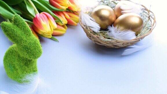 复活节彩蛋篮子里金蛋篮子与春天郁金香白色羽毛在柔和的蓝色背景在快乐复活节装饰传统装饰在阳光下