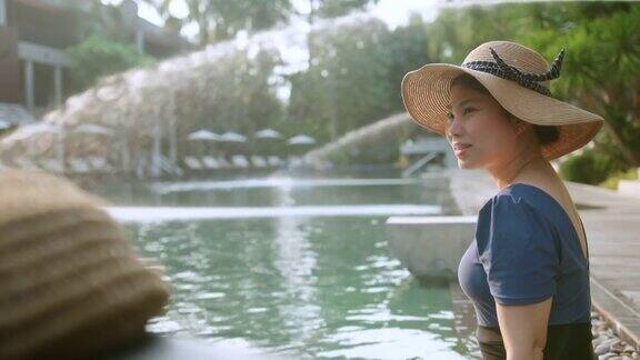 亚洲女性游客穿着休闲服装享受假期日落时刻亚洲女性享受周末旅游游泳池日落时间