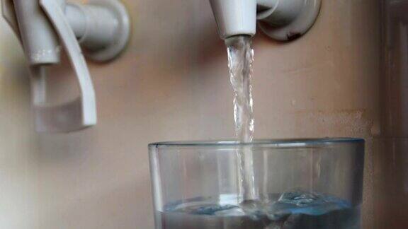 玻璃杯里装满了从饮水机里流出来的水