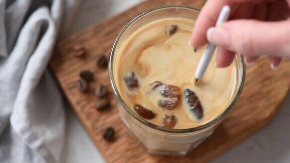 将冰咖啡与奶油混合的慢动作