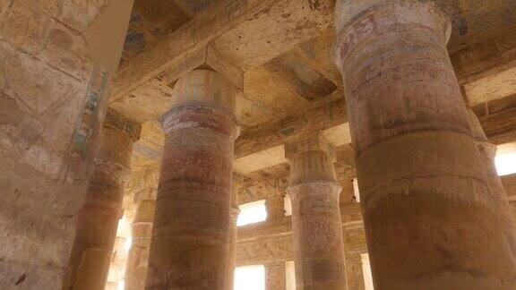 在埃及卢克索的卡纳克神庙建筑群仰望砂岩柱和绘有古画的天花板