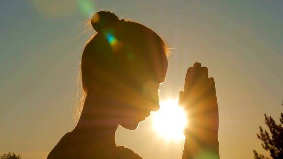 运动妇女在公园祈祷日落