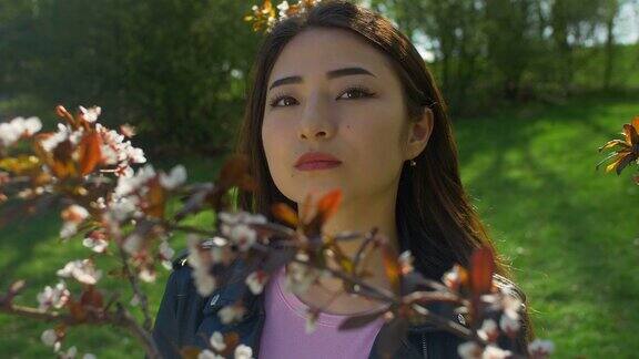 年轻的亚洲女人在盛开的樱花花园