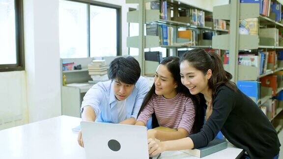 三个大学生互相帮助用笔记本电脑做项目