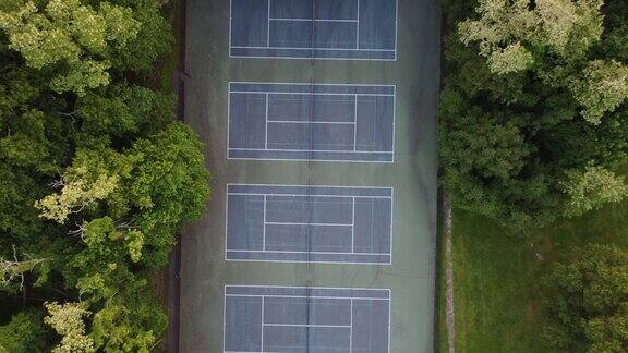 无人机视野的网球场周围的绿色树木