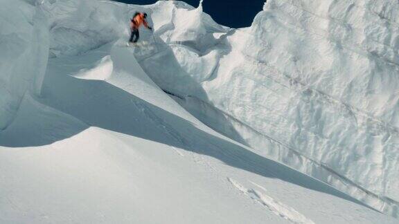 一名专业滑雪者从山坡上下来从雪崖上跳下的视频