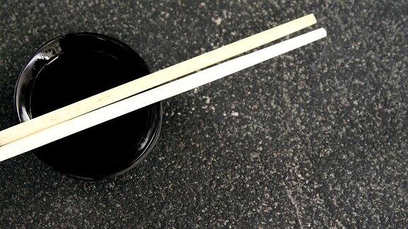 筷子和酱油放在黑色的石板上