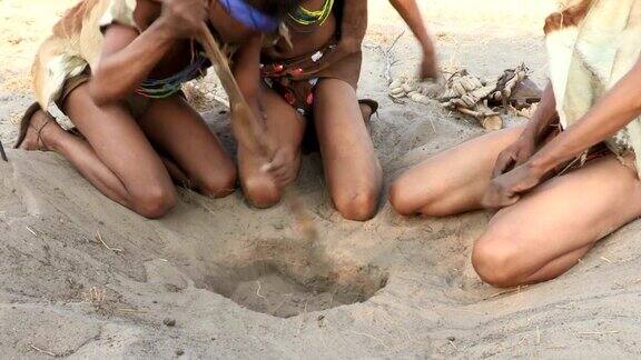 布须曼人从沙洞里挖出一只蝎子