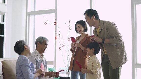 春节期间亚洲华人的祖父母在家给孙子发红包