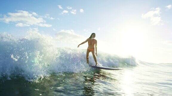 日落冲浪者女孩骑在波浪上