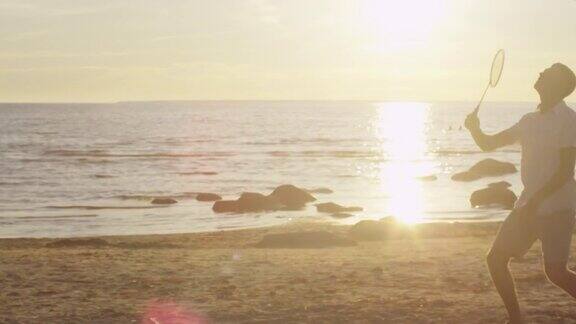 日落时分女孩和男人在沙滩上打羽毛球