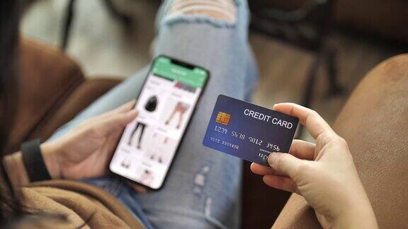 网上购物的女人用信用卡在智能手机上购物